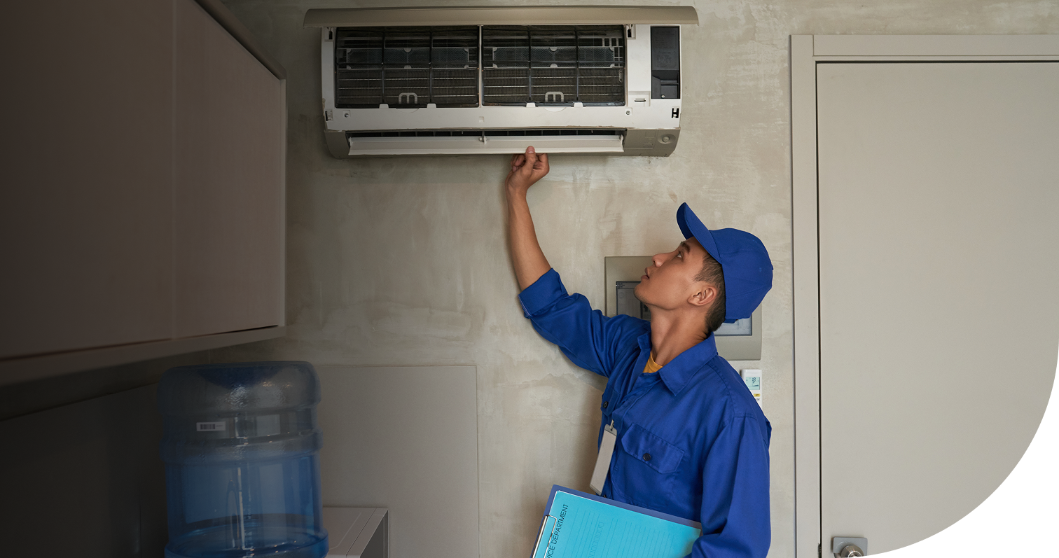 AC technician servicing a wall-mounted air conditioner